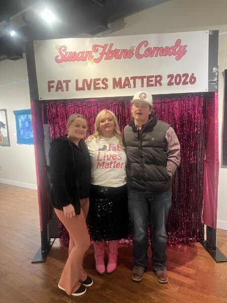 Susan with a young woman and young man at the photo backdrop
