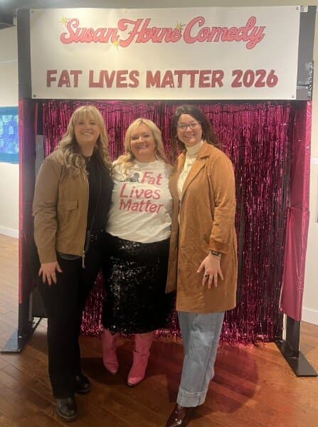 Susan with two friends at the photo backdrop