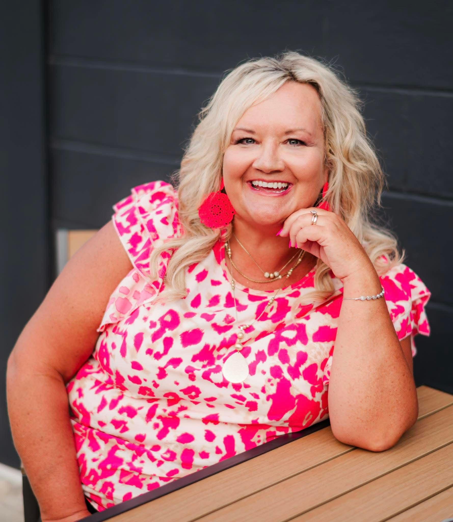 Susan Horne smiling in a pink leopard print top